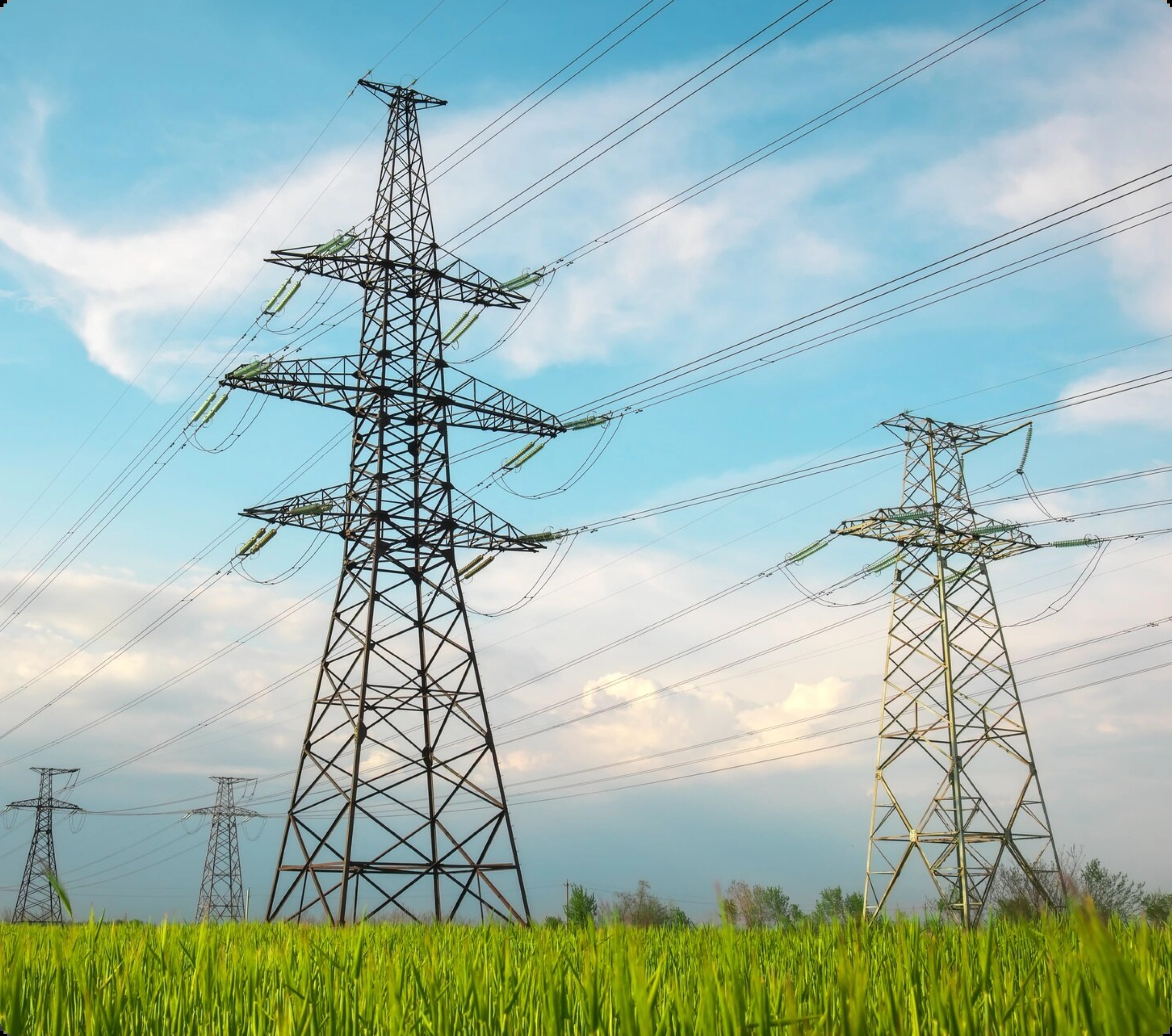 Power transmission towers over a green field